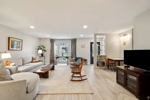 a living room with furniture and a wooden floor