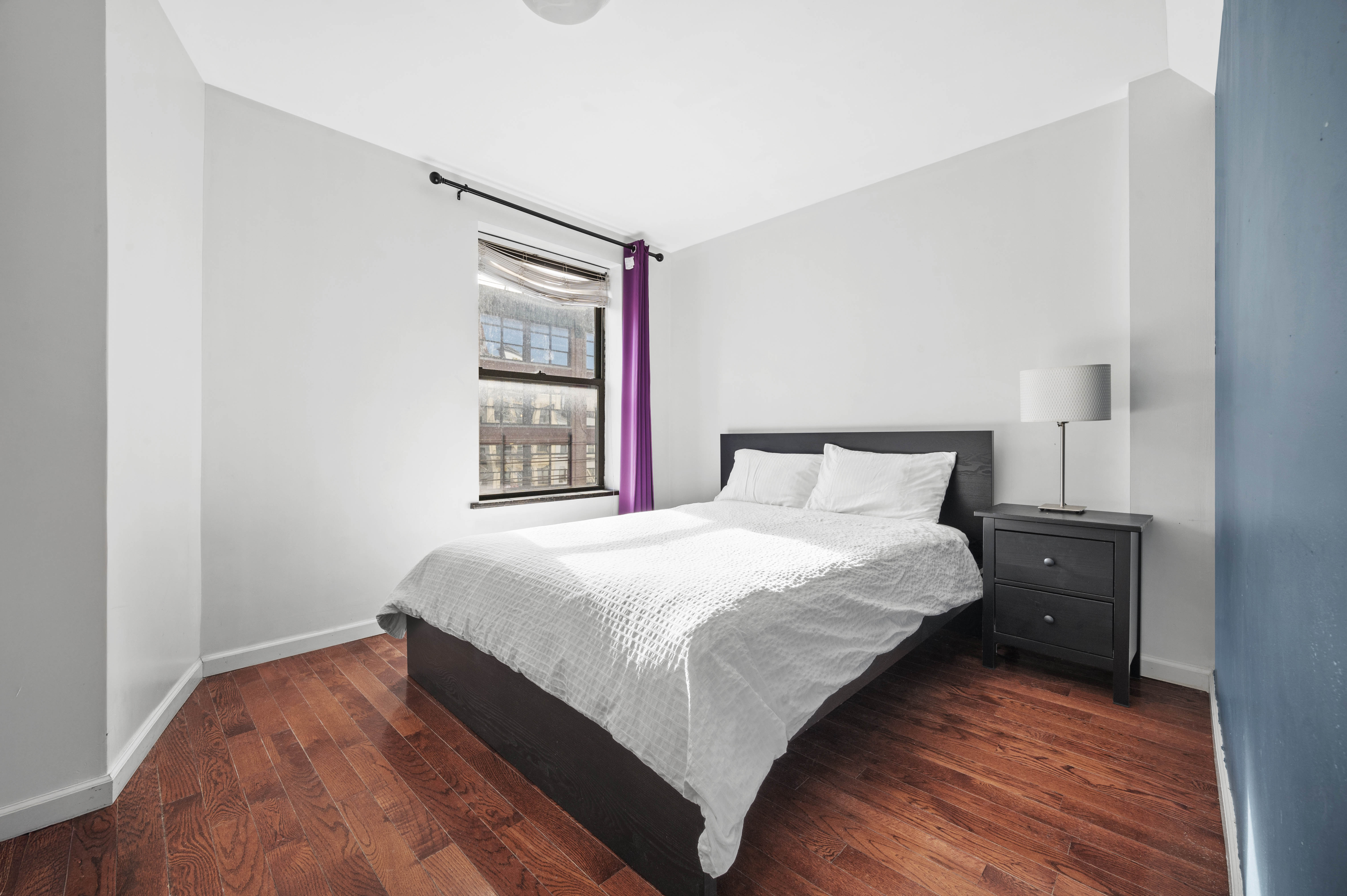 40 East Broadway, Unit 5 Manhattan, NY 10002 - Photo 5 of 10 a bedroom with a bed and wooden floor