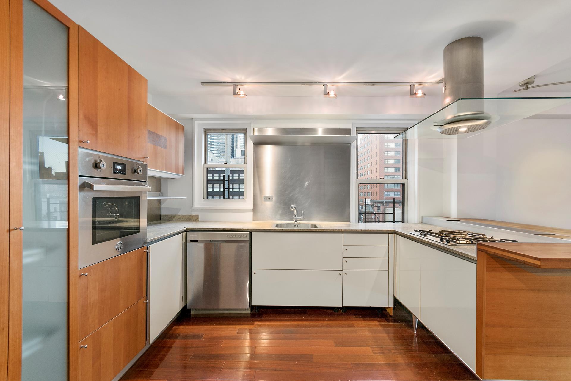 220 East 60th Street, Unit 7CD Manhattan, NY 10022 - Photo 2 of 11 a kitchen with stainless steel appliances granite countertop a sink and stove top oven
