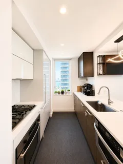 a kitchen with sink a stove and cabinets
