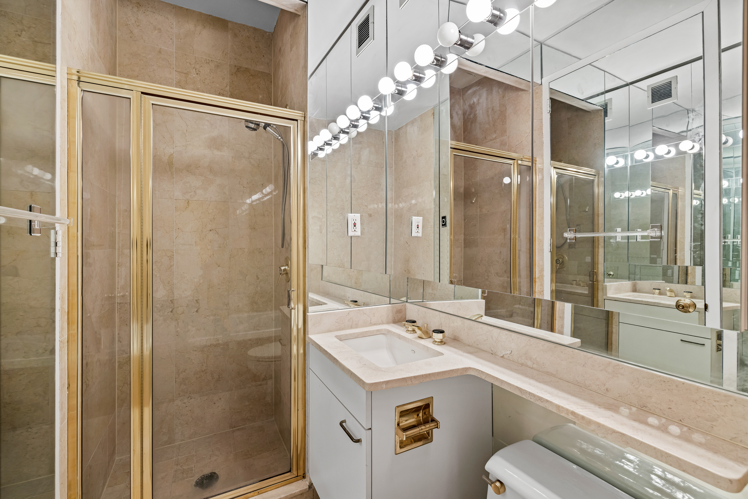 524 East 72nd Street, Unit 31AG Manhattan, NY 10021 - Photo 9 of 17 a bathroom with a shower sink vanity mirror and shower
