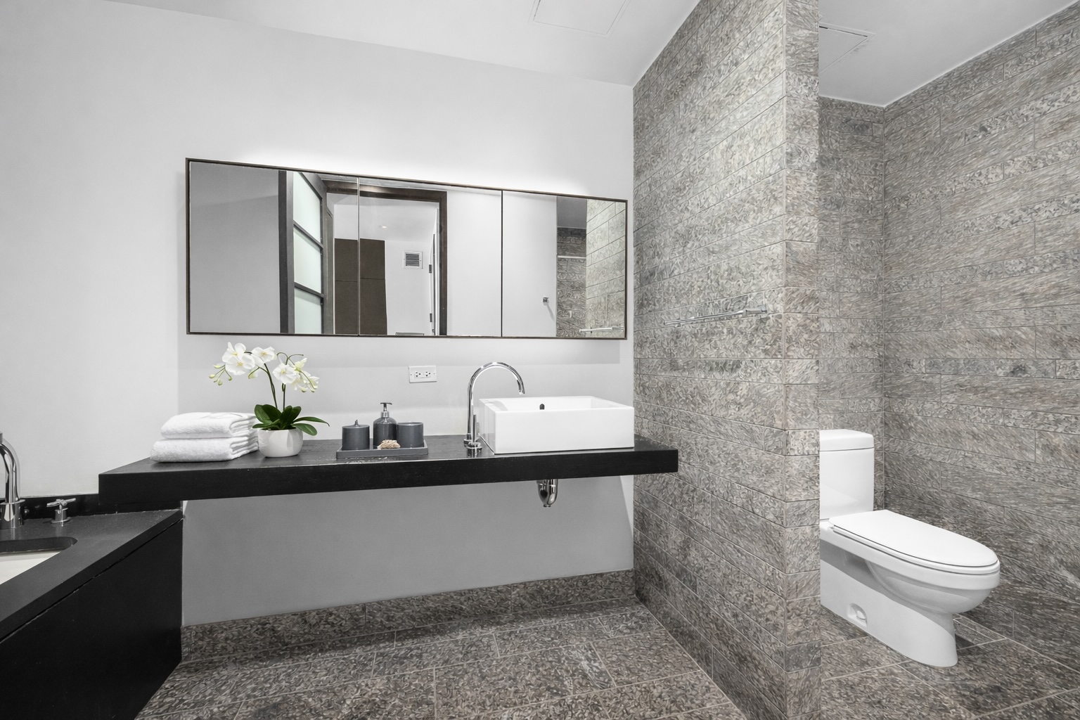 20 Pine Street, Unit 2410 Manhattan, NY 10005 - Photo 4 of 6 a bathroom with a double vanity sink toilet and mirror