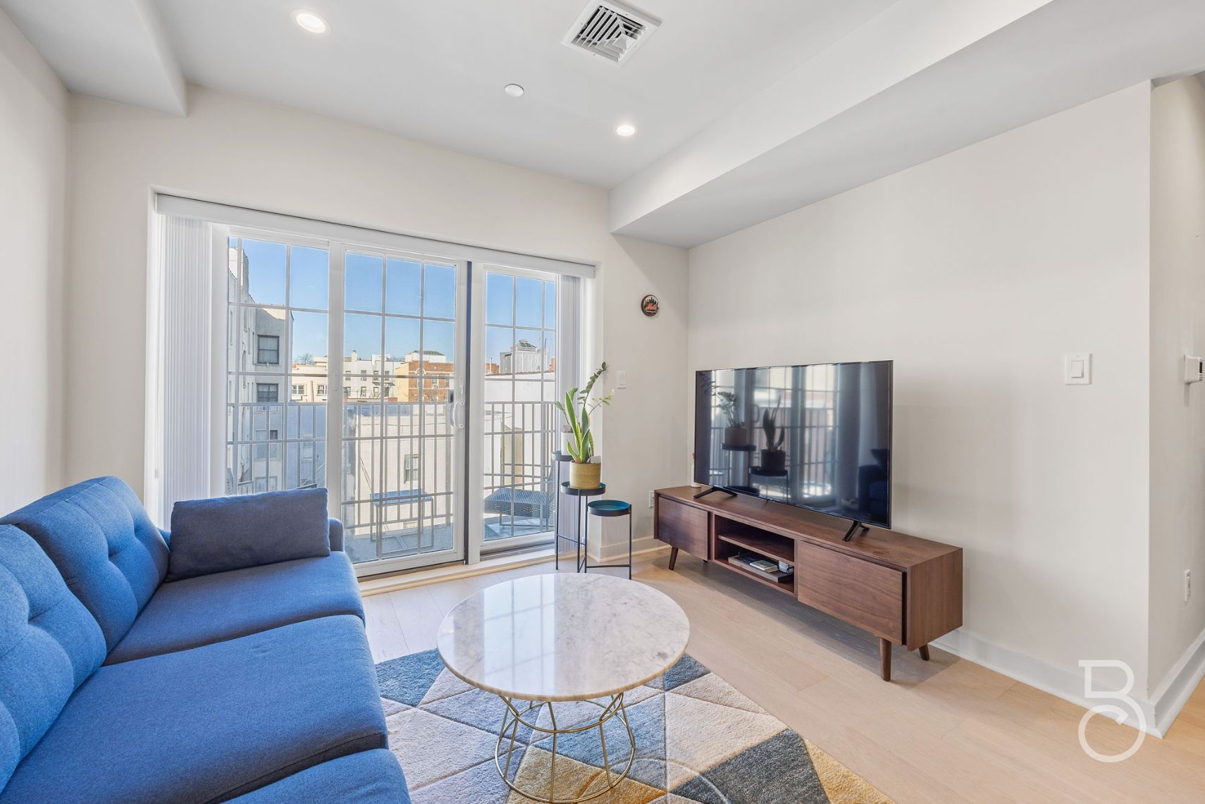 25-74 34th Street, Unit 4C Queens, NY 11103 - Photo 5 of 15 a living room with furniture and a floor to ceiling window