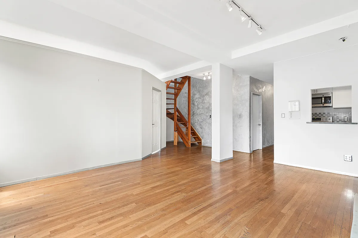 221 East 82nd Street, Unit 6A Manhattan, NY 10028 - Photo 3 of 11 a view of empty room with wooden floor and stairs