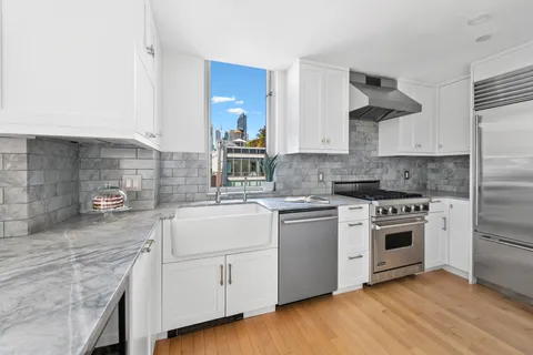 a kitchen with white cabinets stainless steel appliances and sink