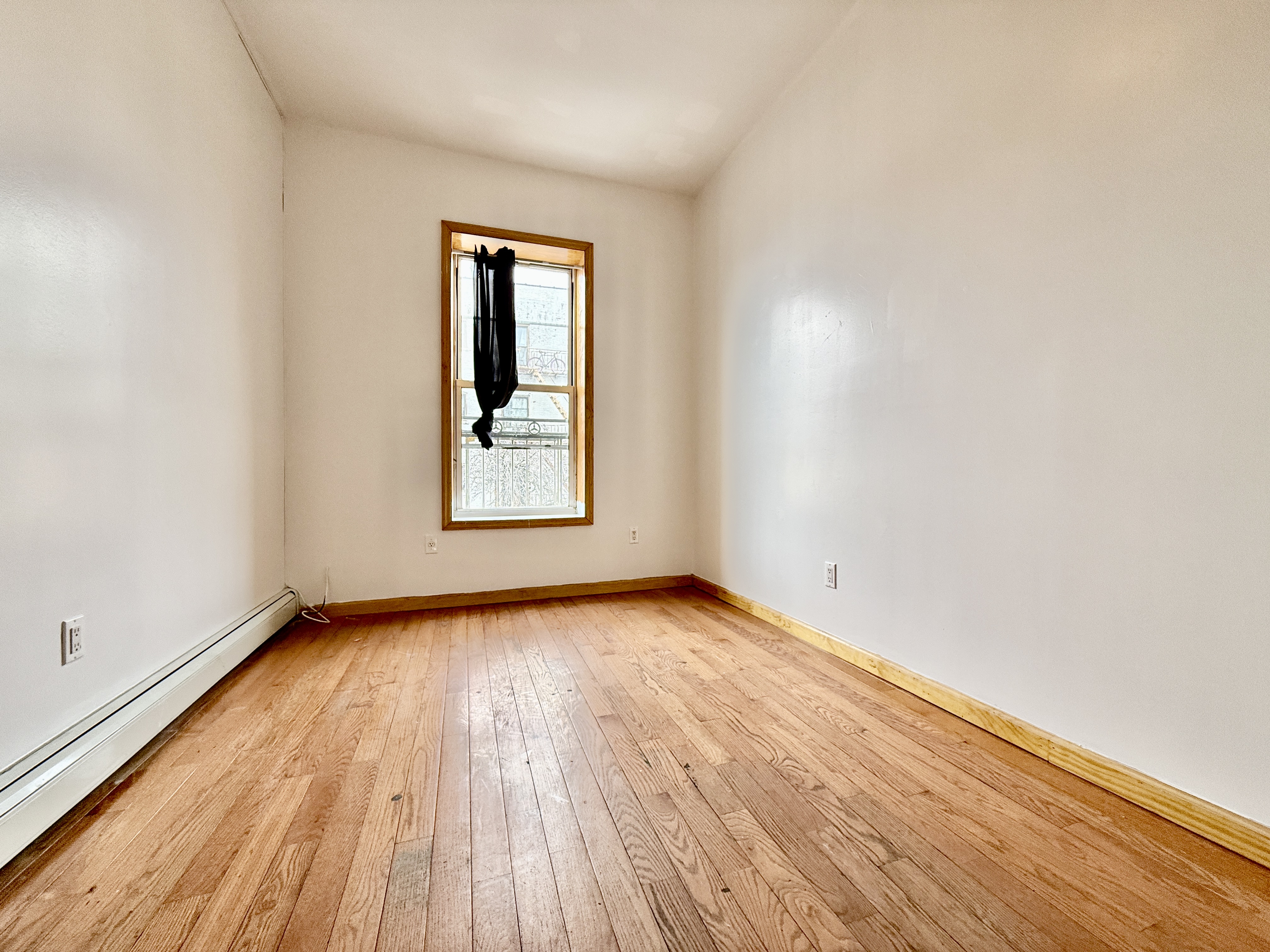 543 53rd Street, Unit 1 Brooklyn, NY 11220 - Photo 3 of 8 an empty room with wooden floor and windows