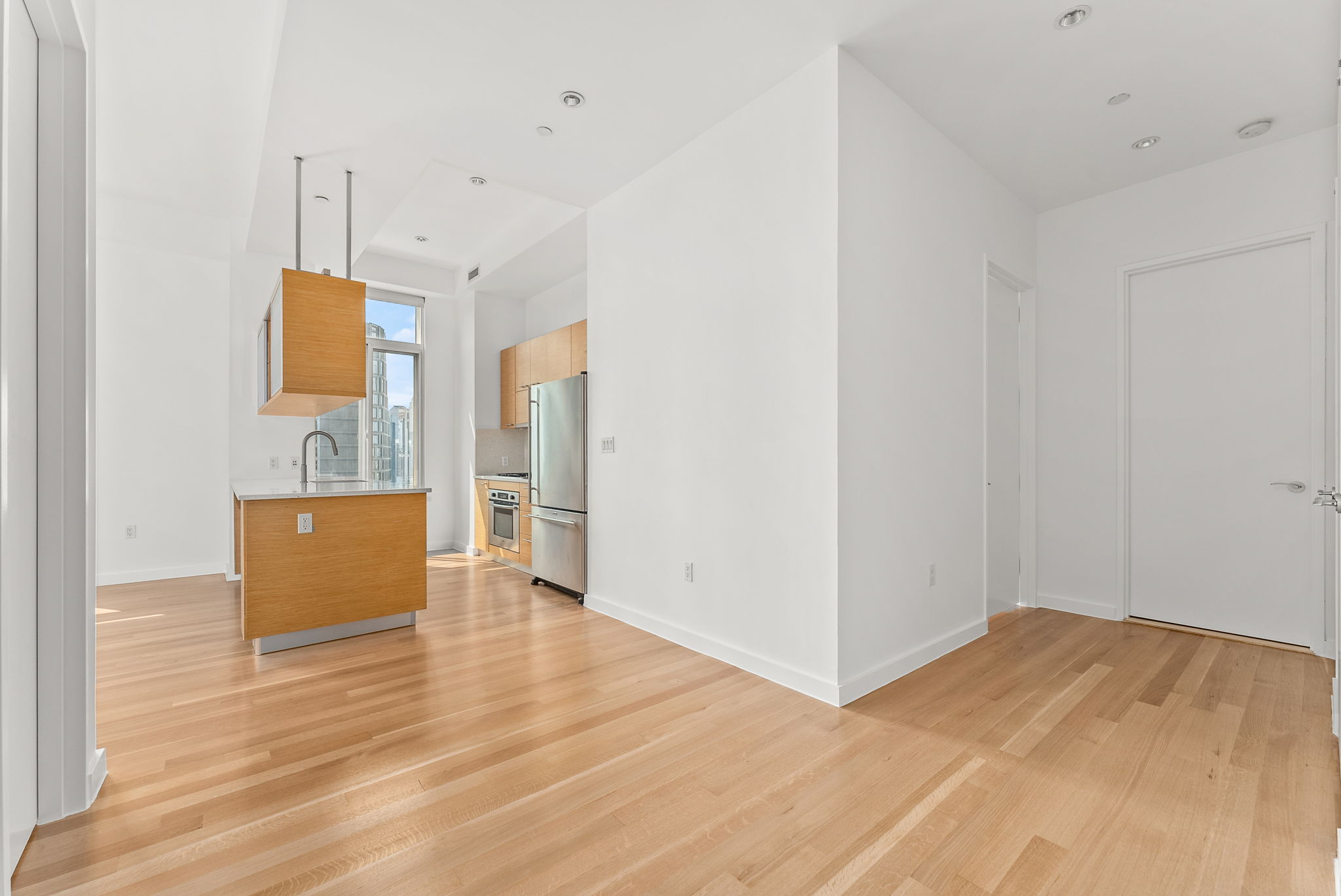 85 Adams Street, Unit 21A Brooklyn, NY 11201 - Photo 6 of 18 a view of a kitchen with wooden floor and a ceiling fan