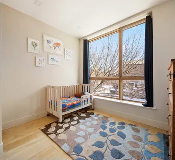 a view of a bedroom with wooden floor