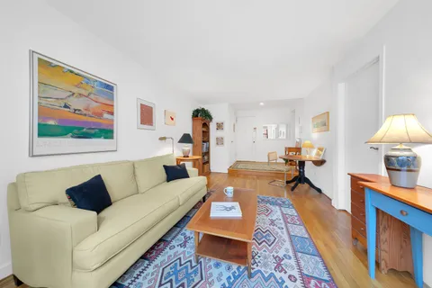 a living room with furniture and a wooden floor