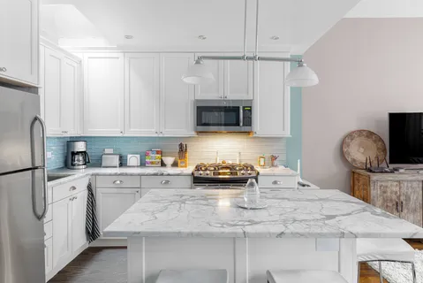 a kitchen with stainless steel appliances granite countertop a sink a stove and a refrigerator