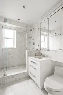 a bathroom with a sink a toilet and shower