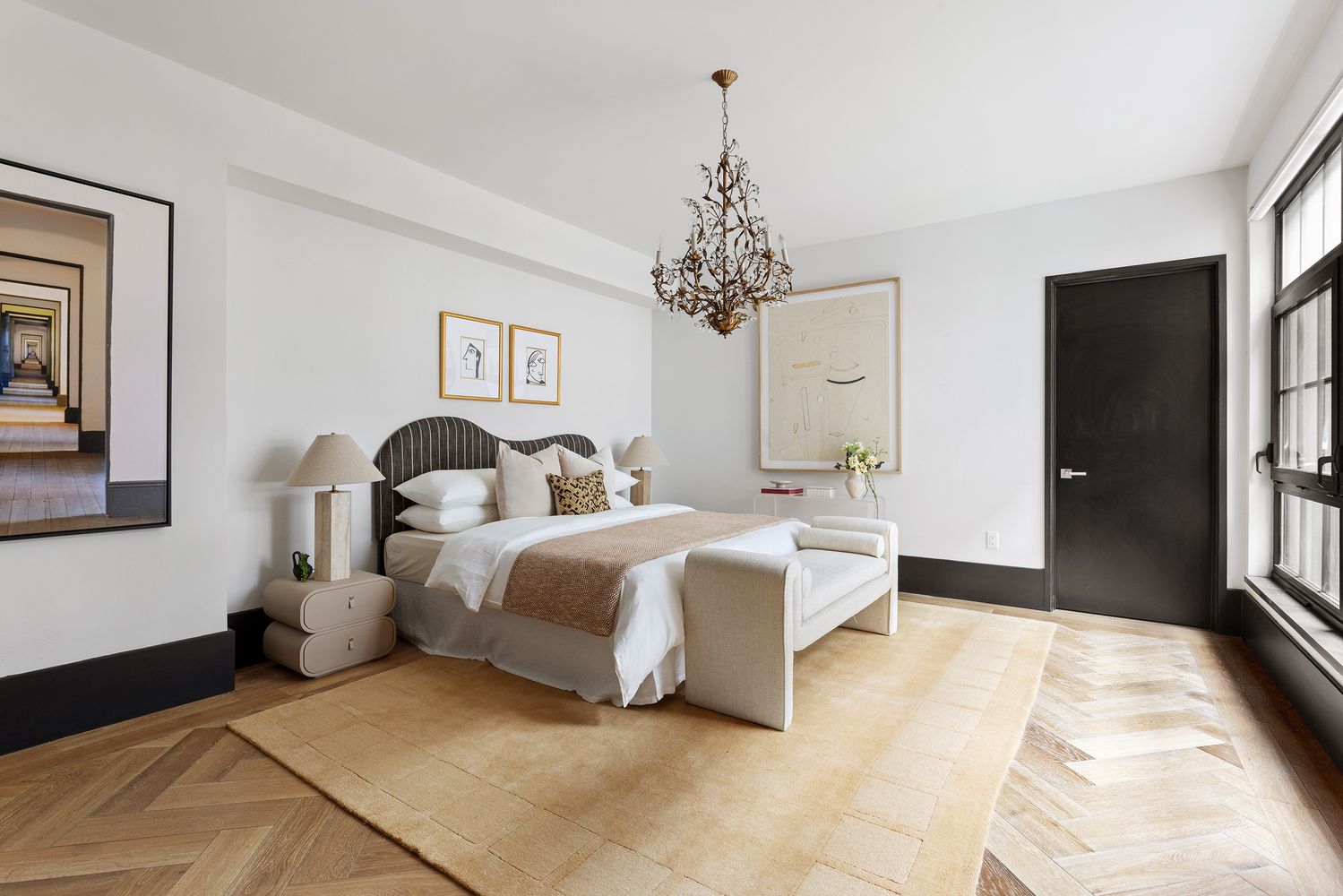 a spacious bedroom with a bed and a chandelier