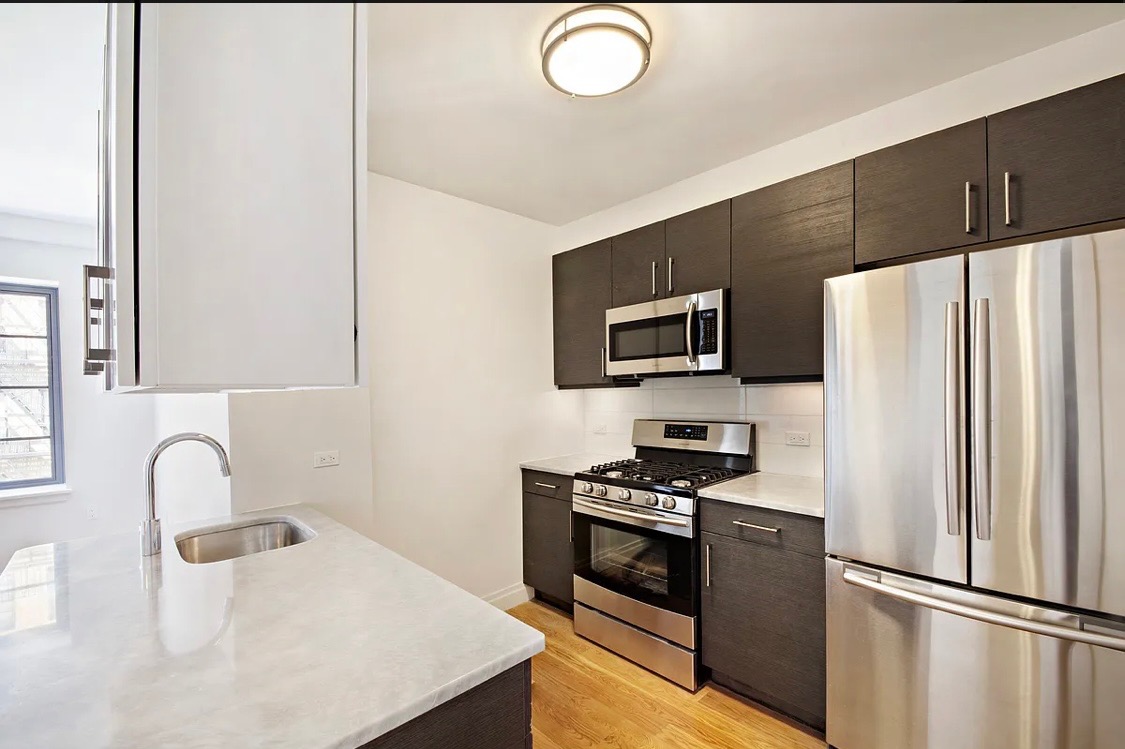 58 West 129th Street, Unit 5A Manhattan, NY 10027 - Photo 3 of 7 a kitchen with stainless steel appliances a refrigerator stove and microwave