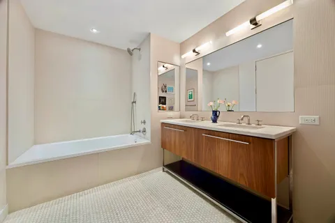 a bedroom with a bed and a dresser next to a window