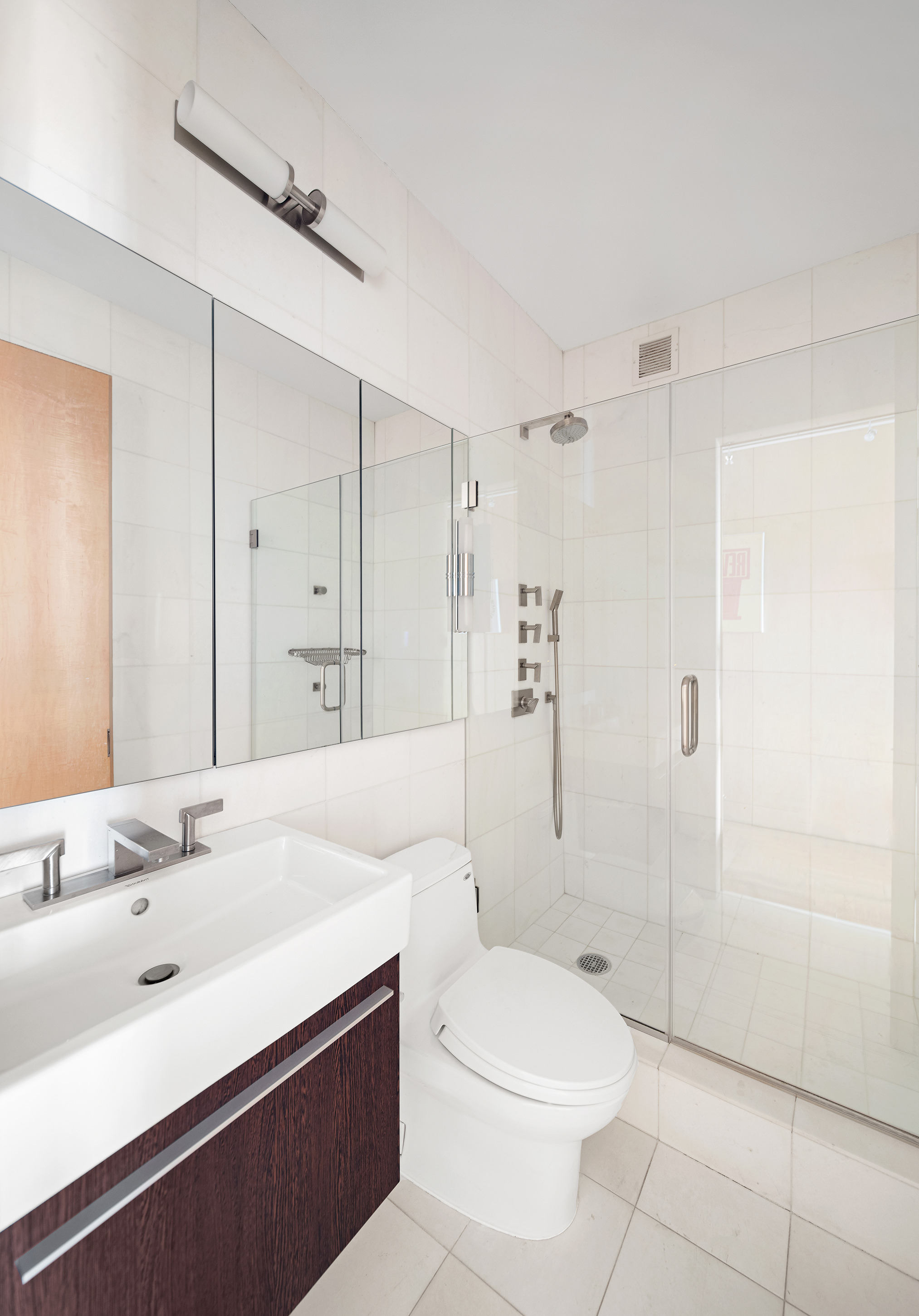 524 East 72nd Street, Unit 28DE Manhattan, NY 10021 - Photo 13 of 14 a bathroom with a sink a toilet and shower