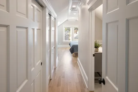 a view of a hallway with wooden floor and staircase