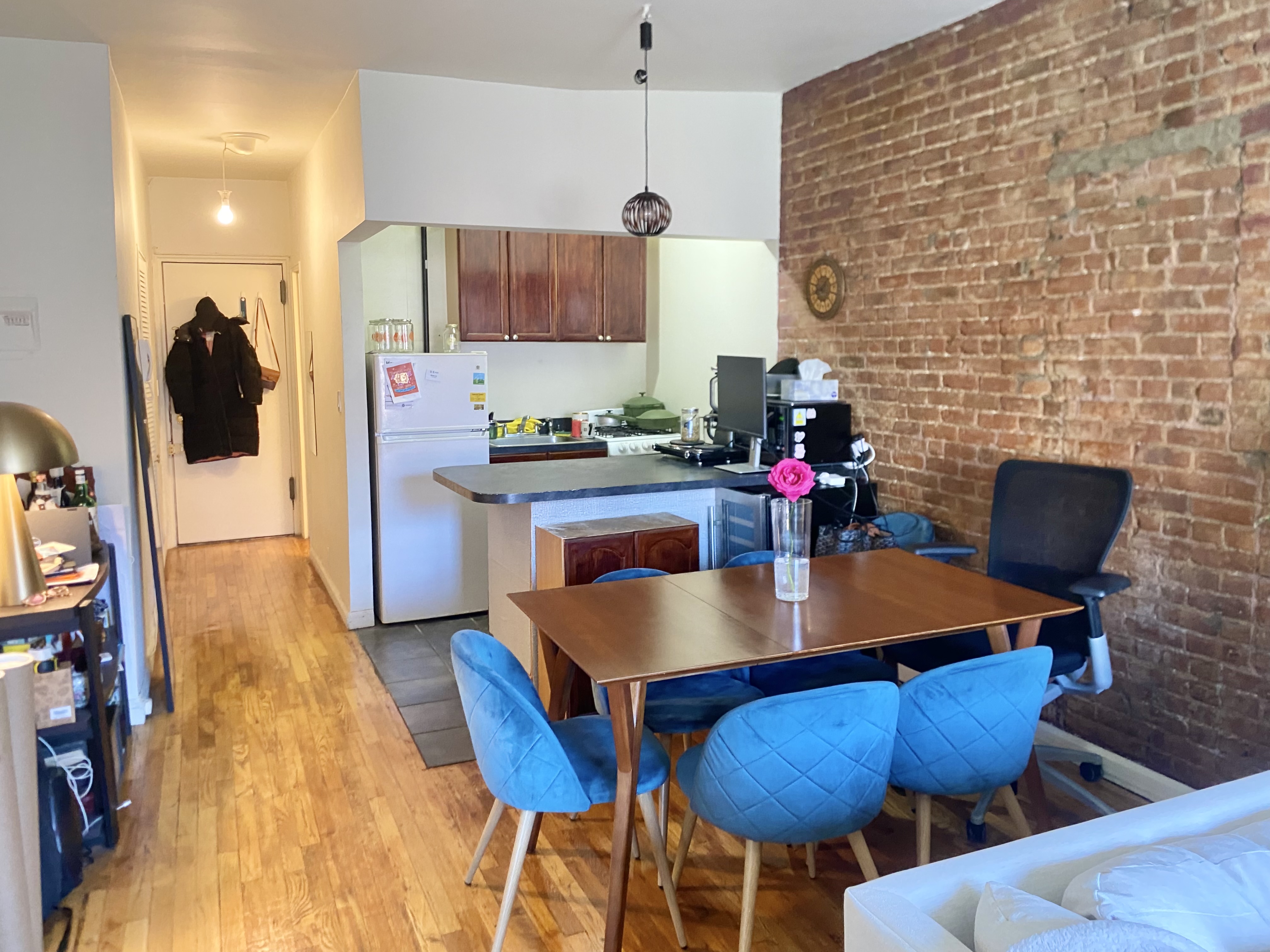 108 Perry Street, Unit 3C Manhattan, NY 10014 - Photo 3 of 6 a kitchen with stainless steel appliances dining table chairs and a wooden floor