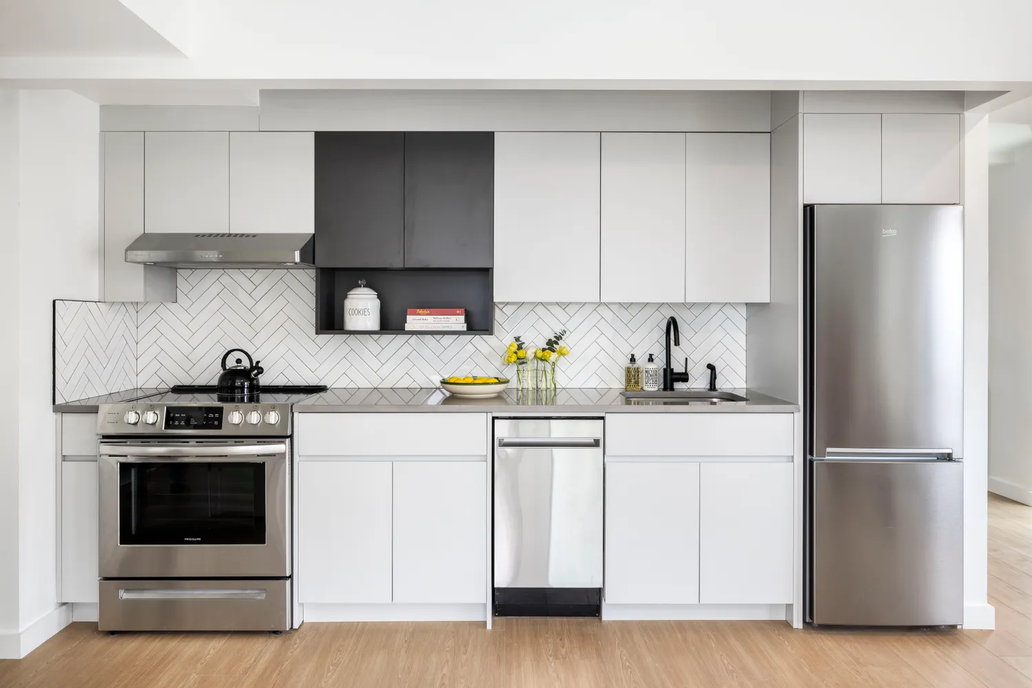 a kitchen with cabinets appliances and a wooden floor
