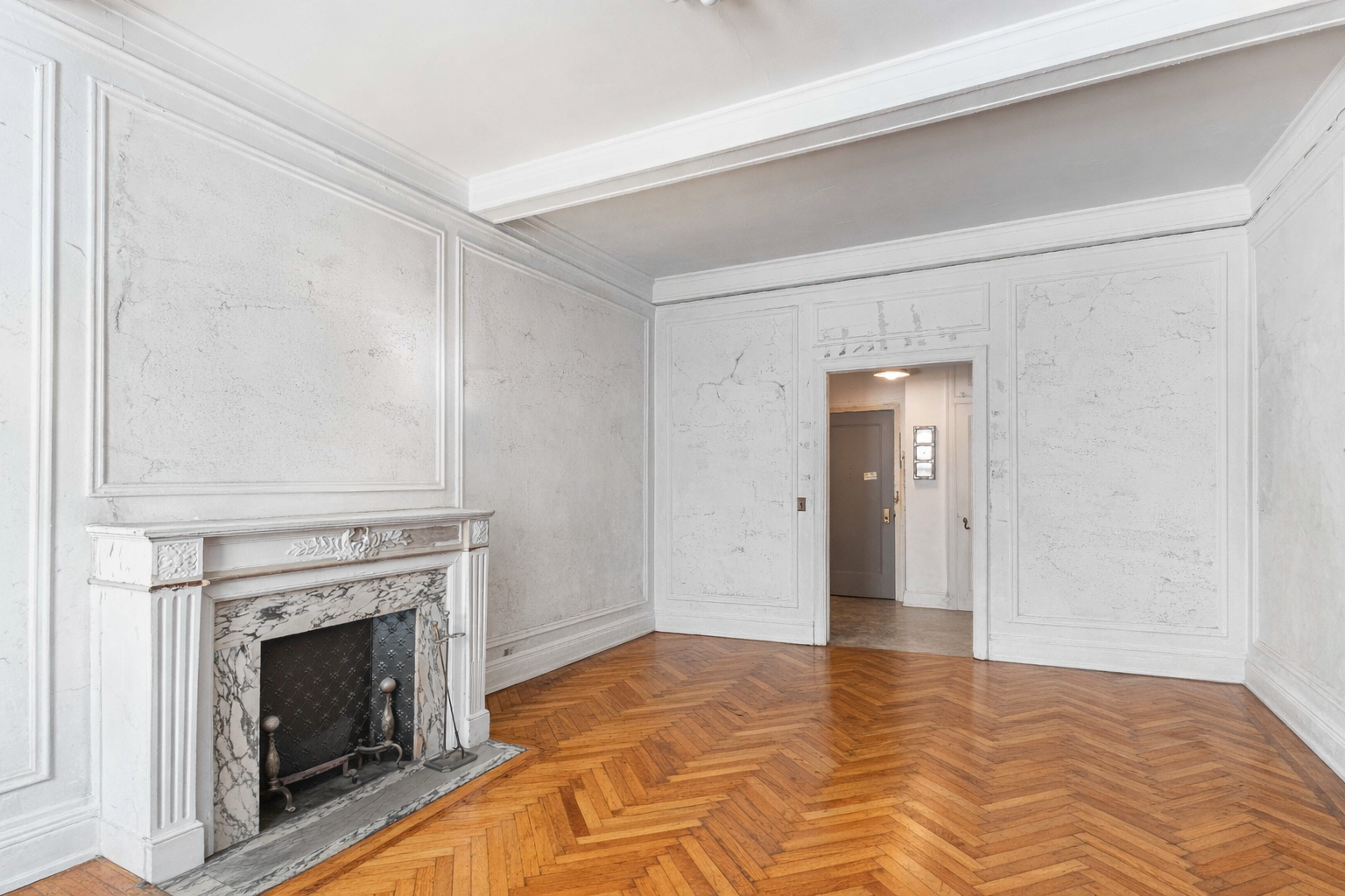 302 West 86th Street, Unit 1C Manhattan, NY 10024 - Photo 3 of 16 a view of an empty room with wooden floor fireplace and a window
