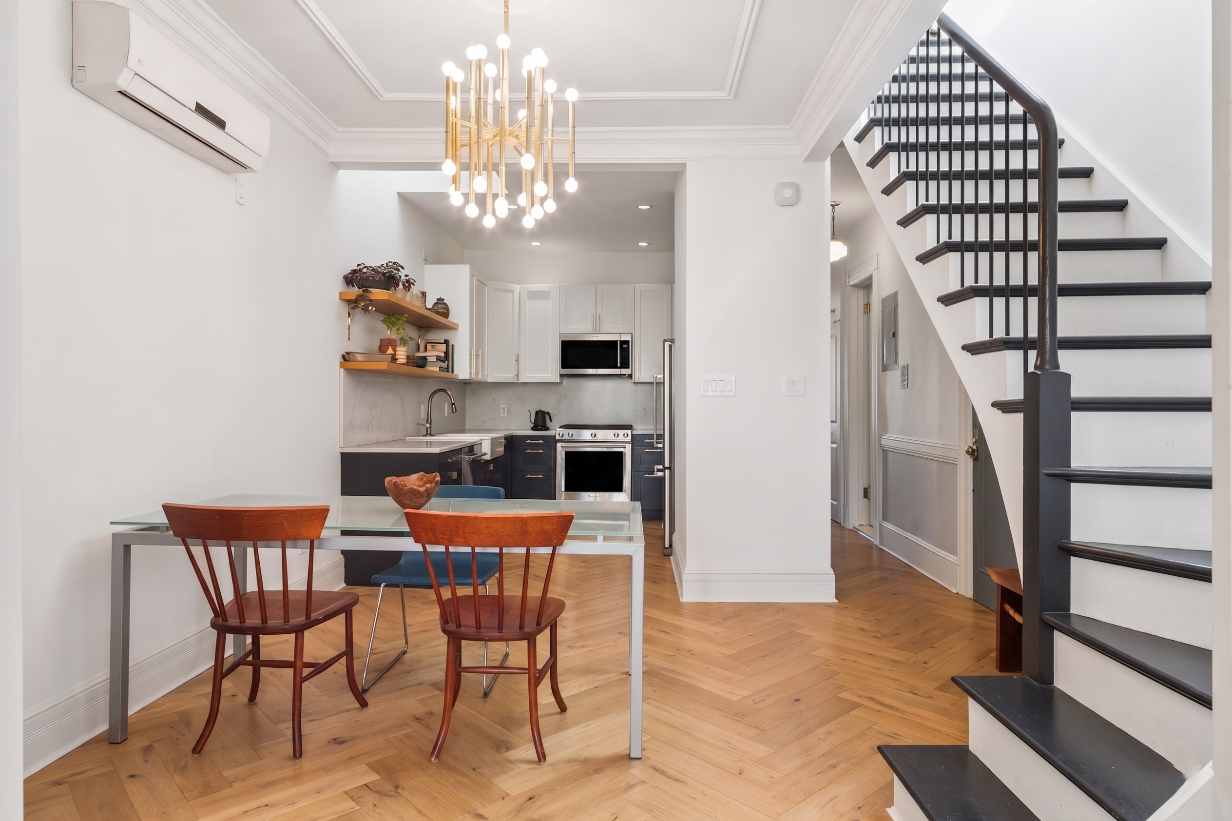 a dining room with furniture a chandelier and wooden floor