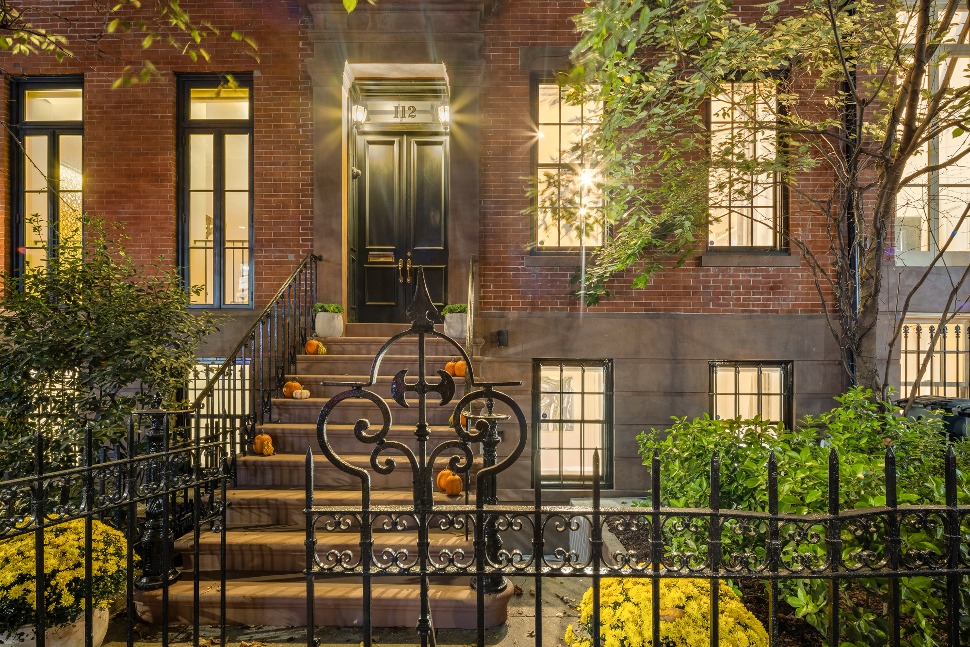 112 West 13th Street Manhattan, NY 10011 - Photo 2 of 46 a view of a brick house with large windows and a table and chairs