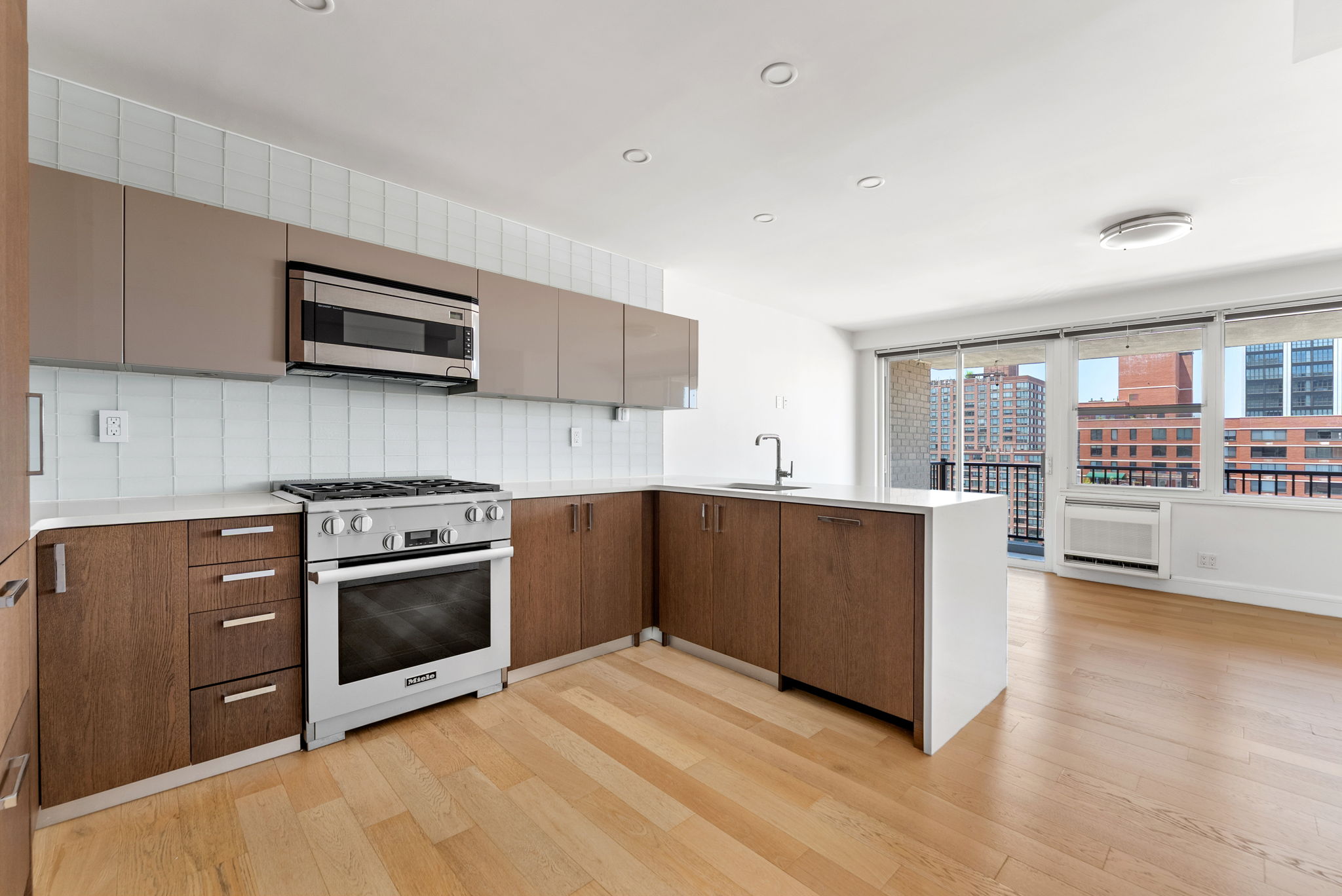 175 West 95th Street, Unit 15D Manhattan, NY 10025 - Photo 4 of 13 a kitchen with stainless steel appliances kitchen island granite countertop a stove a sink and a microwave