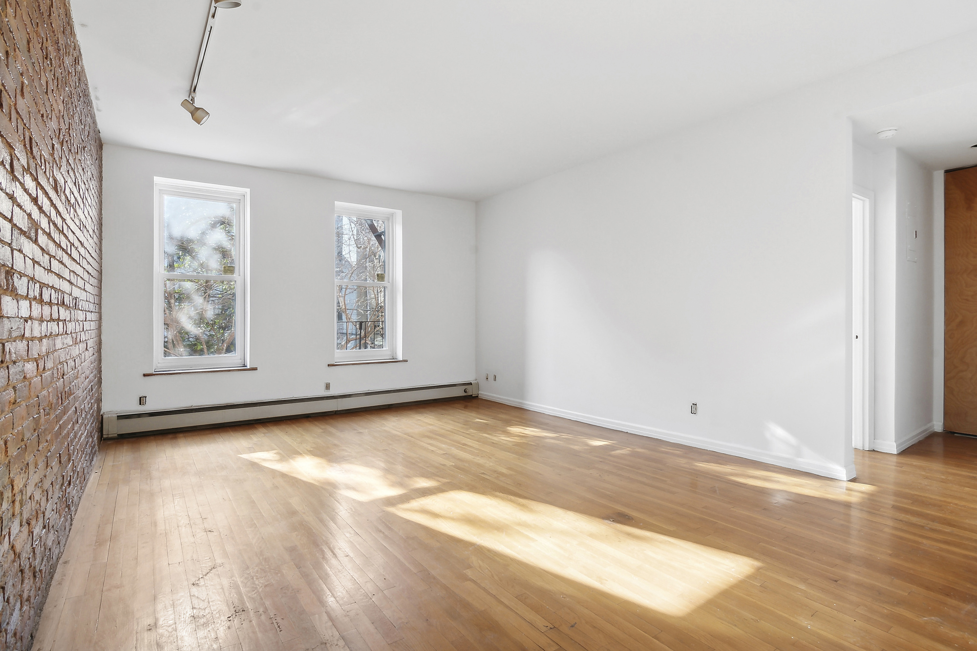 426 13th Street, Unit 2C Brooklyn, NY 11215 - Photo 4 of 13 a view of an empty room with wooden floor and a window