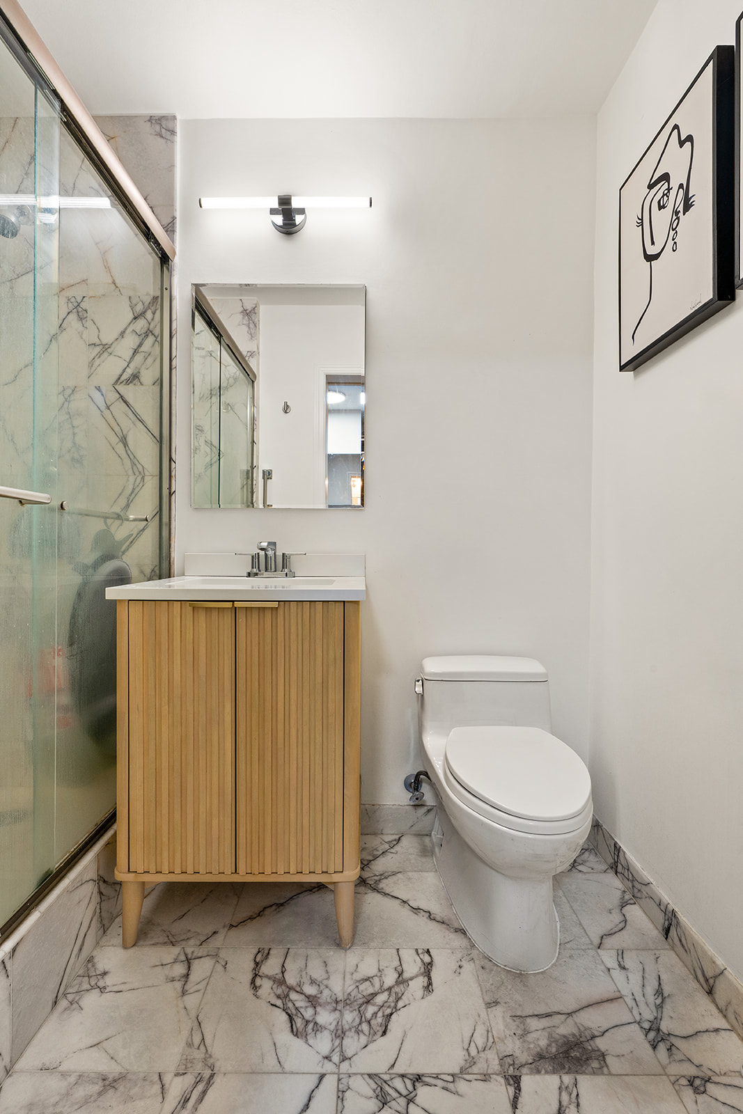 1160 3rd Avenue, Unit 4EF Manhattan, NY 10065 - Photo 6 of 11 a bathroom with a sink a toilet and mirror