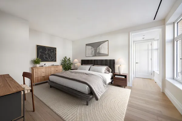 a bedroom with a bed a couch and a flat screen tv