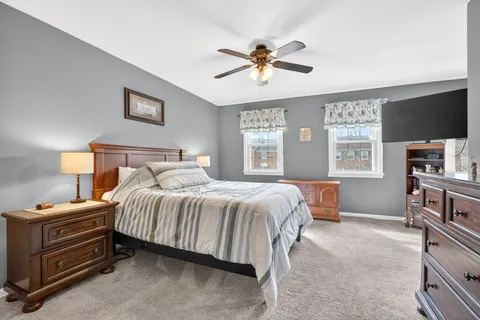 a bedroom with a bed and a mirror on dresser