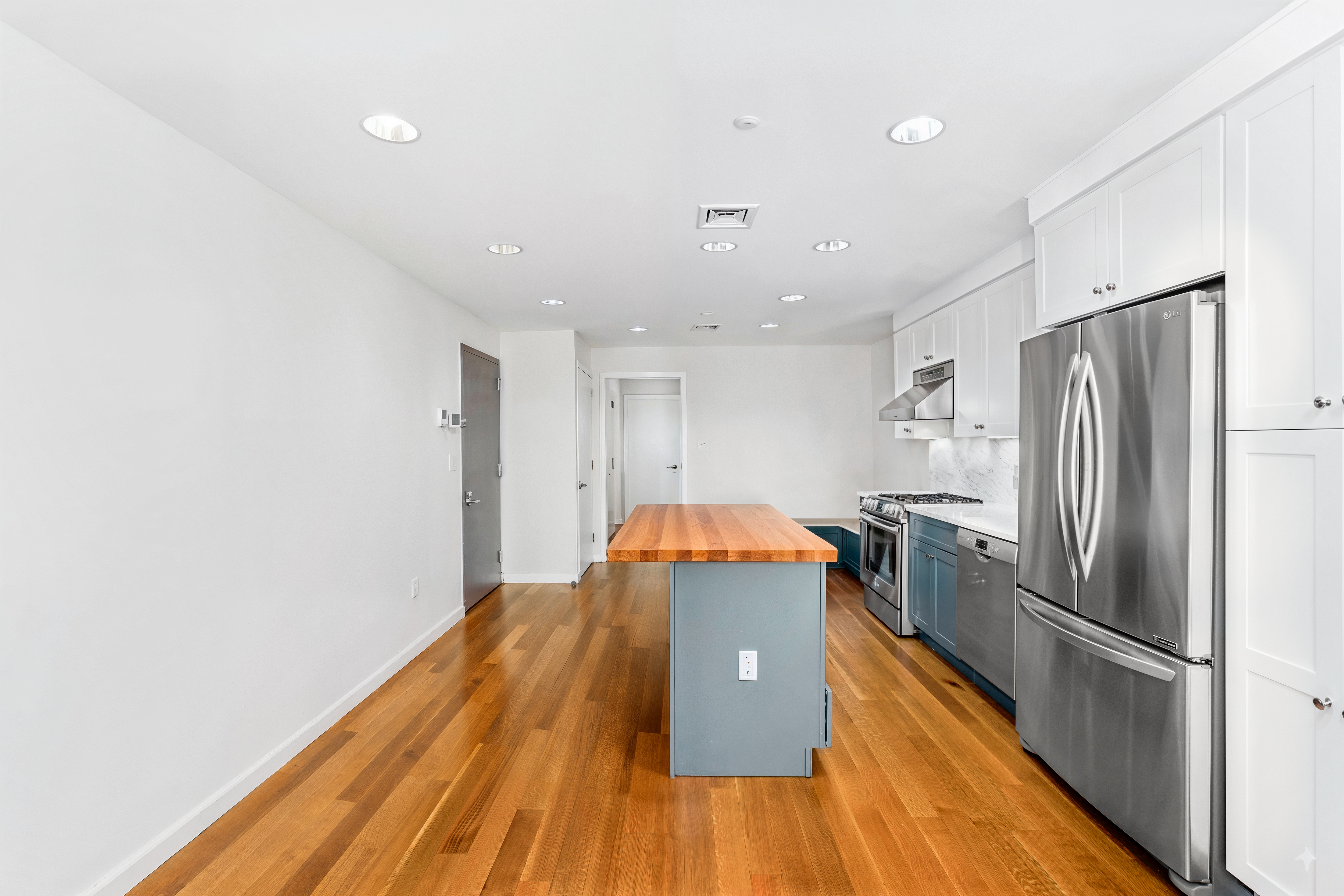 324 20th Street, Unit 2E Brooklyn, NY 11215 - Photo 4 of 11 a kitchen with stainless steel appliances a refrigerator and a wooden floor