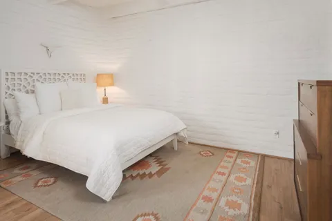 a bedroom with a bed and a night stand