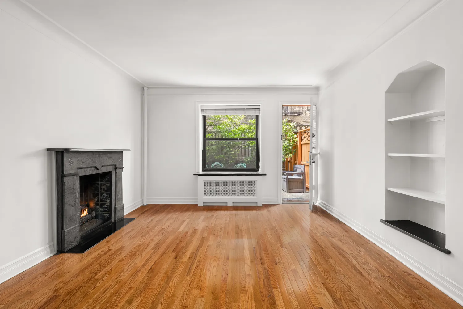 a view of empty room with wooden floor and fireplace