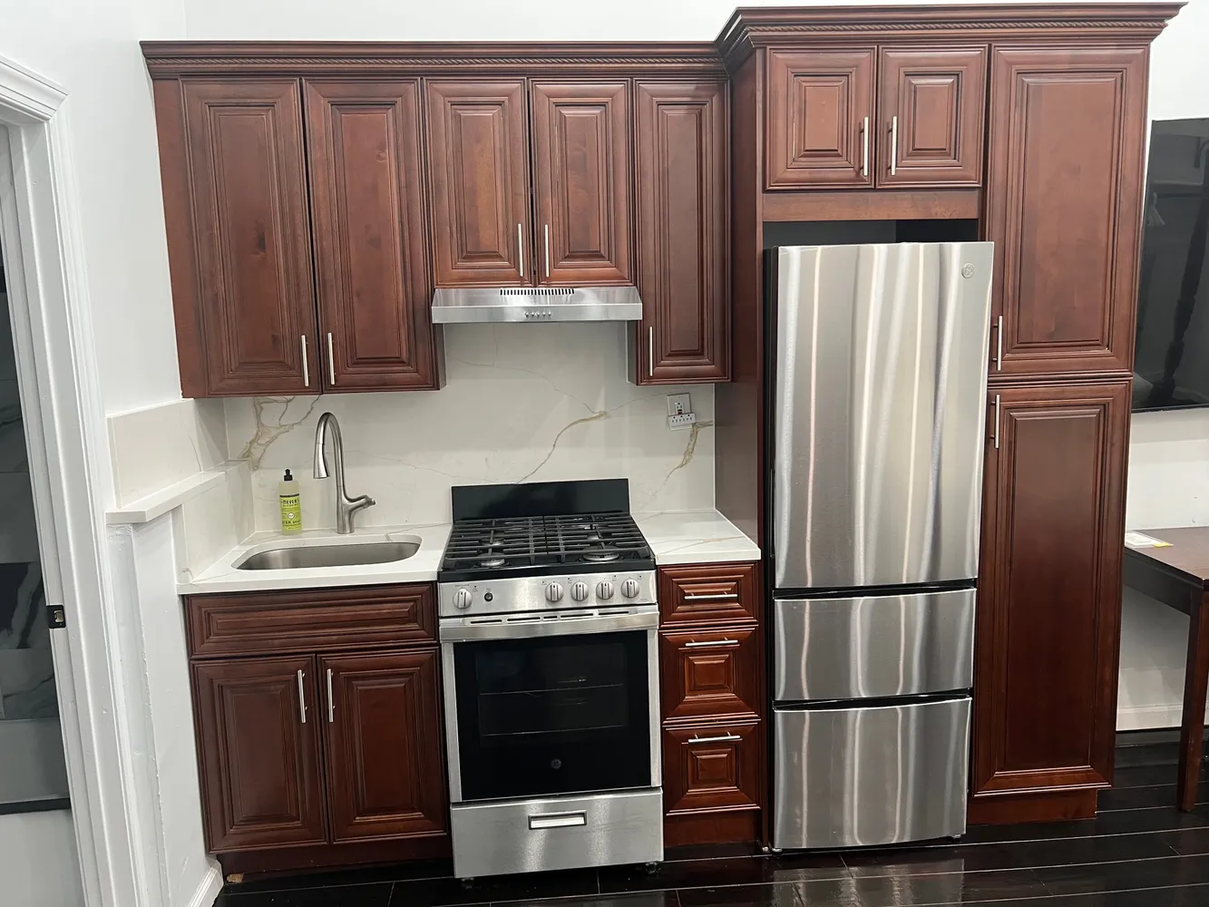 a kitchen with stainless steel appliances granite countertop a refrigerator stove and sink