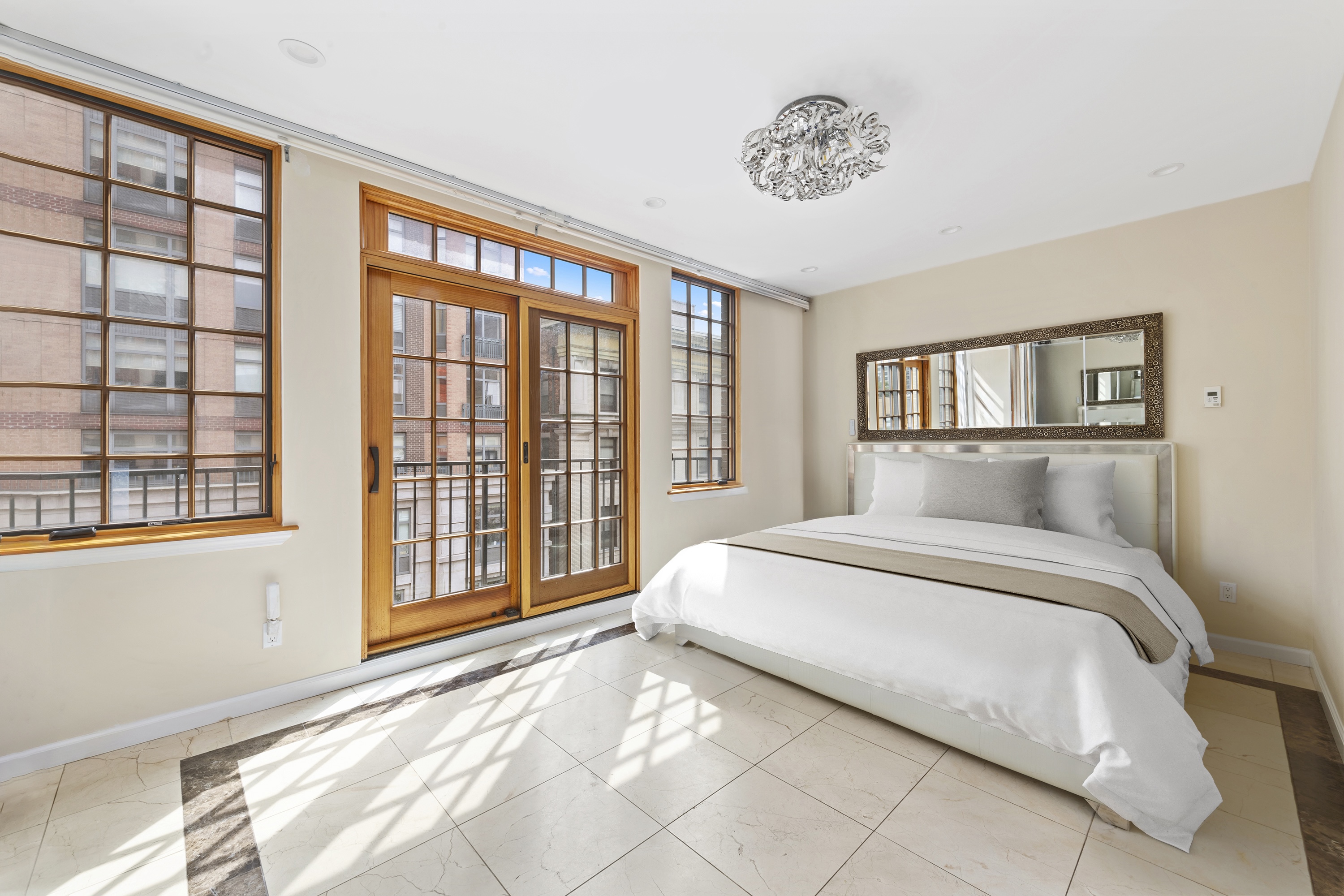195 East 76th Street Manhattan, NY 10021 - Photo 12 of 20 a spacious bedroom with a large bed and a large window