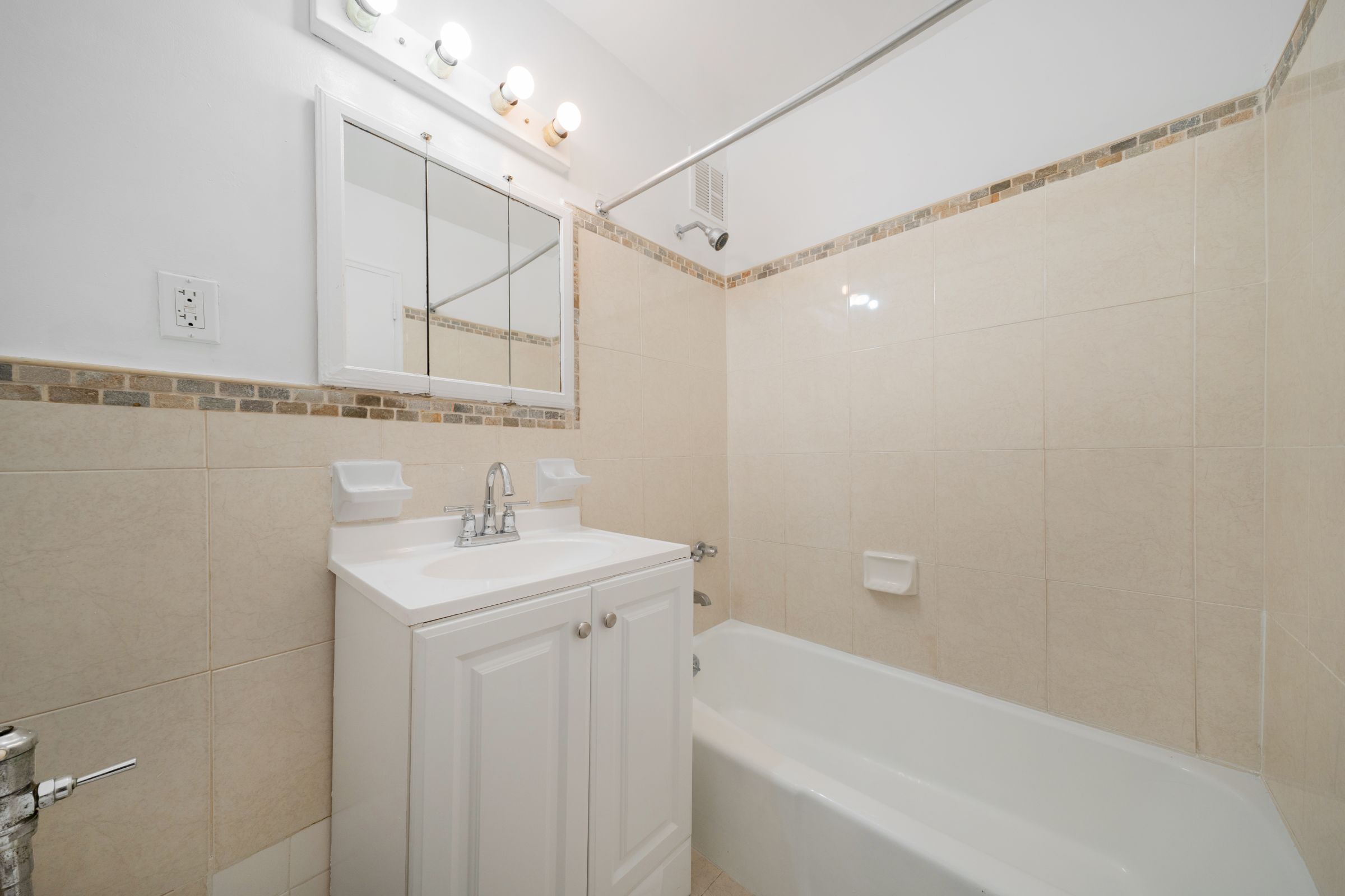 1270 East 51st Street, Unit 6M Brooklyn, NY 11234 - Photo 9 of 12 a bathroom with a bathtub a shower a sink and a window