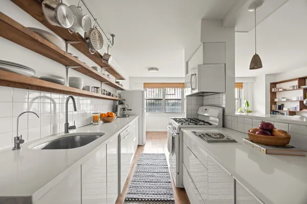 a kitchen that has a lot of cabinets a sink and appliances