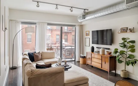 a living room with furniture a flat screen tv and a large window