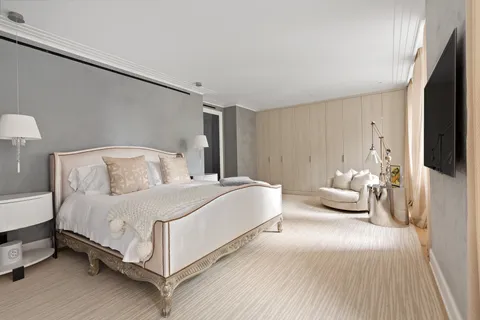 a bedroom with a bed lamp and a flat tv screen