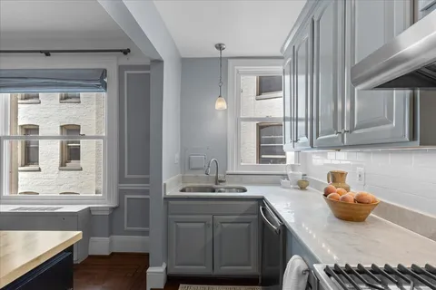 a view of kitchen island a sink wooden floor dining table and chairs