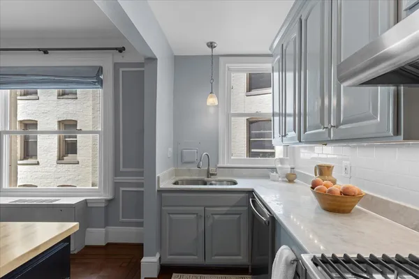 a view of kitchen island a sink wooden floor dining table and chairs