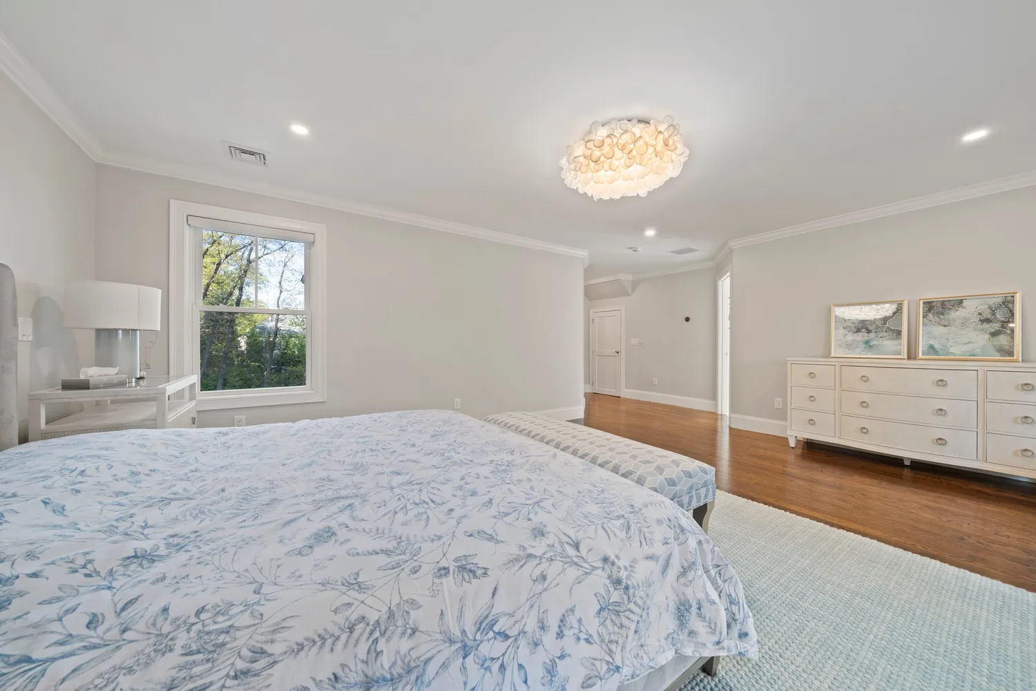 a view of a house with a big yard potted plants and large tree