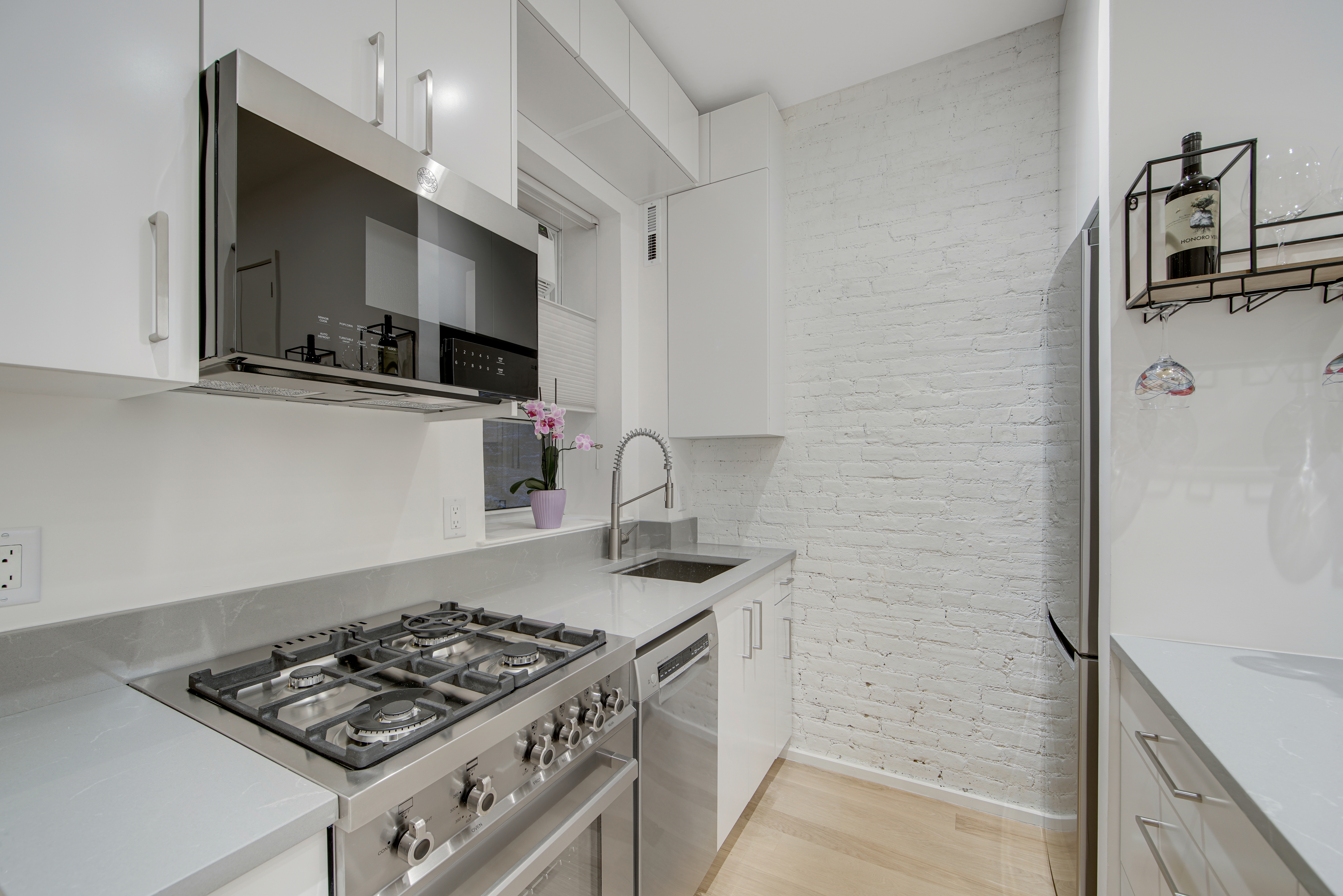 214 West 16th Street, Unit 1W Manhattan, NY 10011 - Photo 5 of 13 a kitchen with stainless steel appliances a stove a sink and a refrigerator