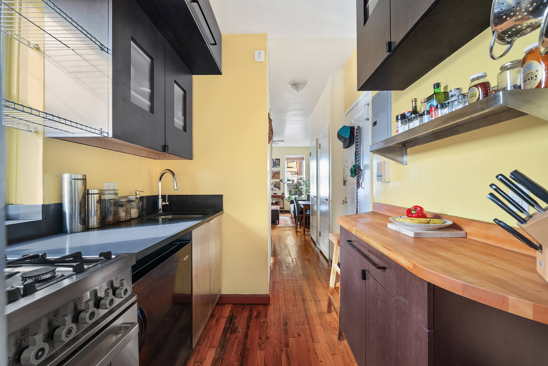 88 Charles Street, Unit 5D Manhattan, NY 10014 - Photo 5 of 11 a kitchen with stainless steel appliances a stove a sink dishwasher and cabinets with wooden floor