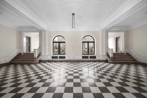 a view of a entryway with a checkered floor and a rug