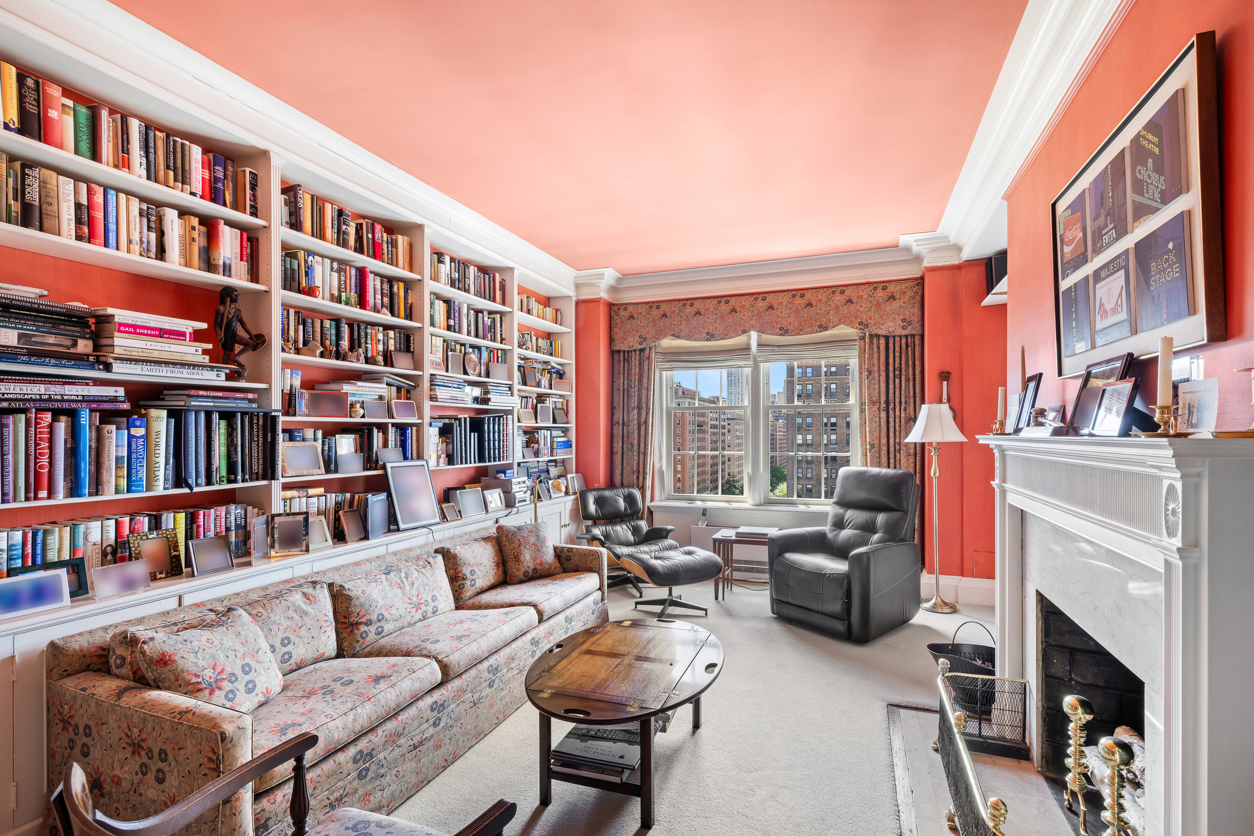 1220 Park Avenue, Unit 12B Manhattan, NY 10128 - Photo 4 of 12 a living room with furniture a bookshelf and a book shelf