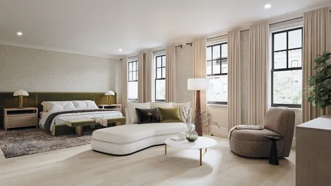 a bedroom with a large bed and windows