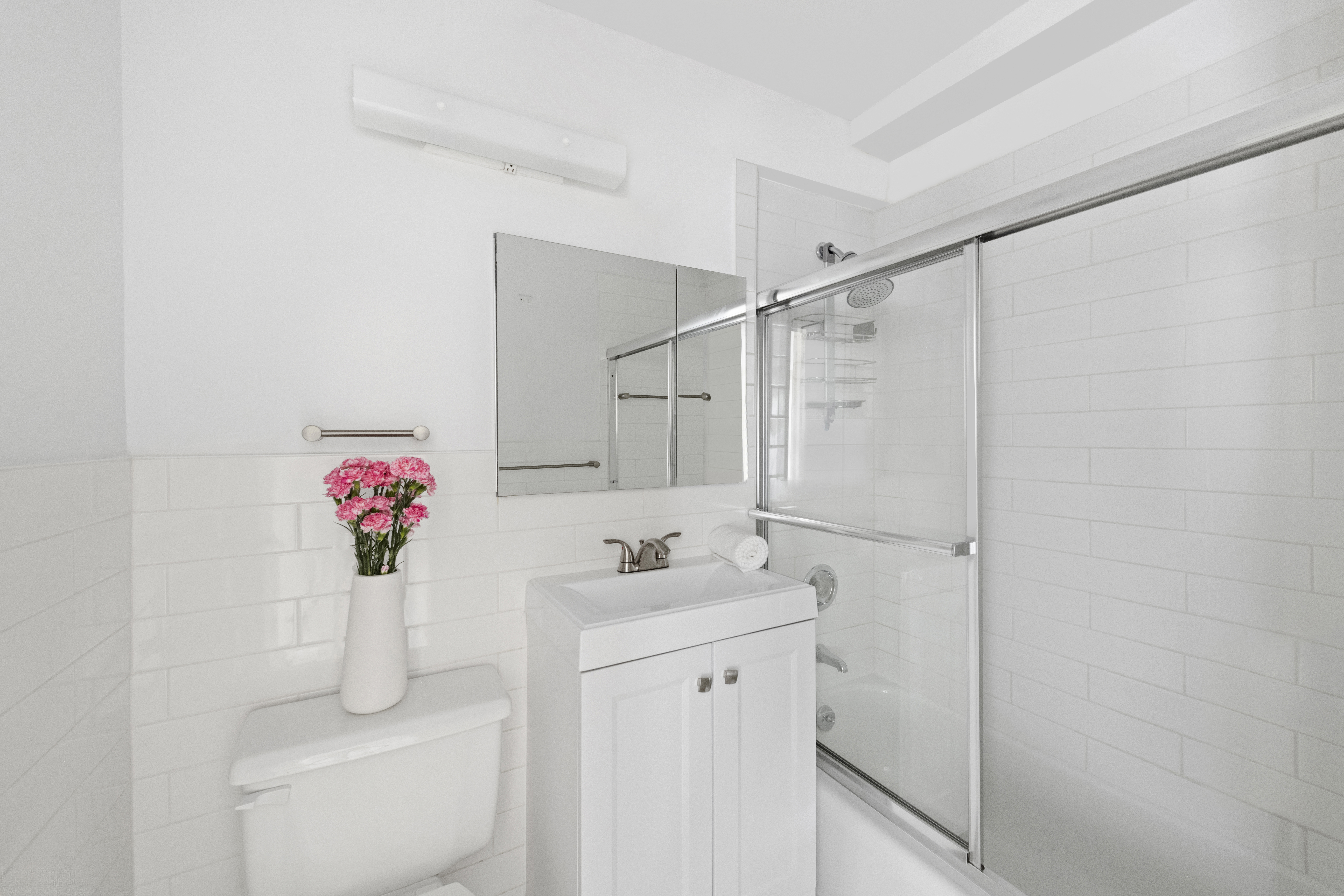7 East 14th Street, Unit 1229 Manhattan, NY 10003 - Photo 5 of 9 a bathroom with a sink vanity mirror and shower