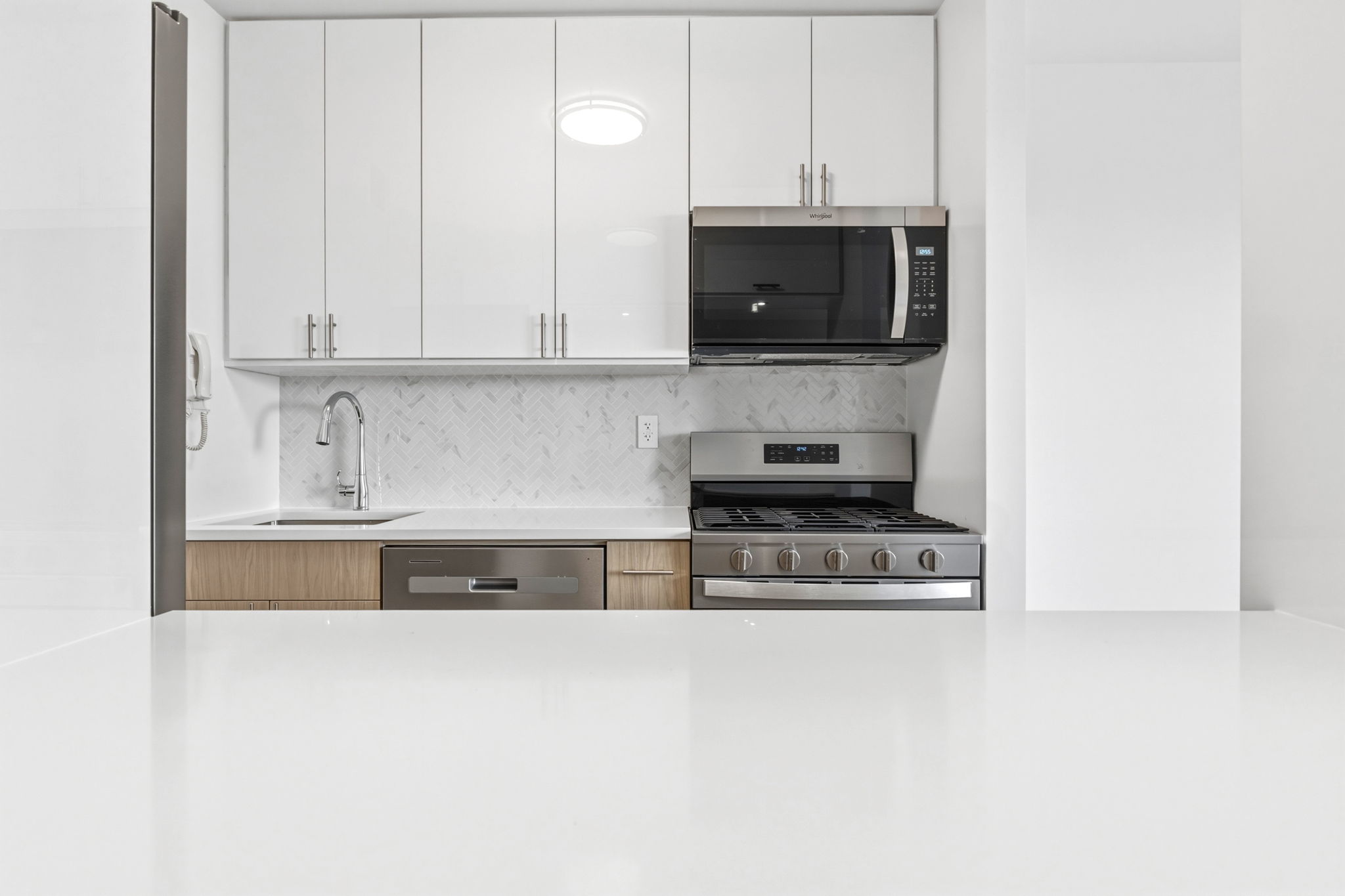 400 East 54th Street, Unit 24E Manhattan, NY 10022 - Photo 9 of 29 a kitchen with stainless steel appliances granite countertop a sink a stove and a microwave