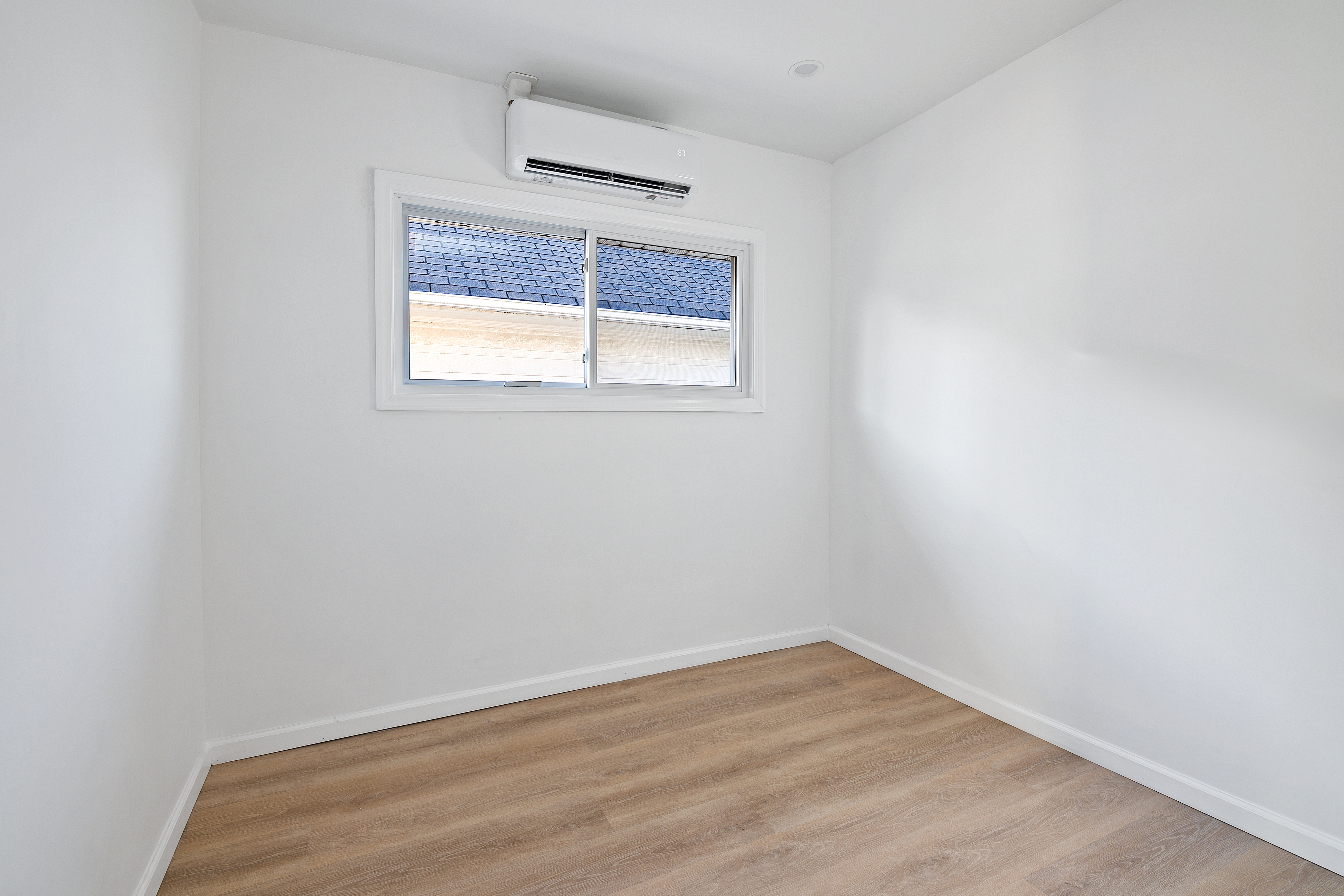 3810 Farragut Road, Unit 1 Brooklyn, NY 11210 - Photo 10 of 13 a view of an empty room with wooden floor and a window